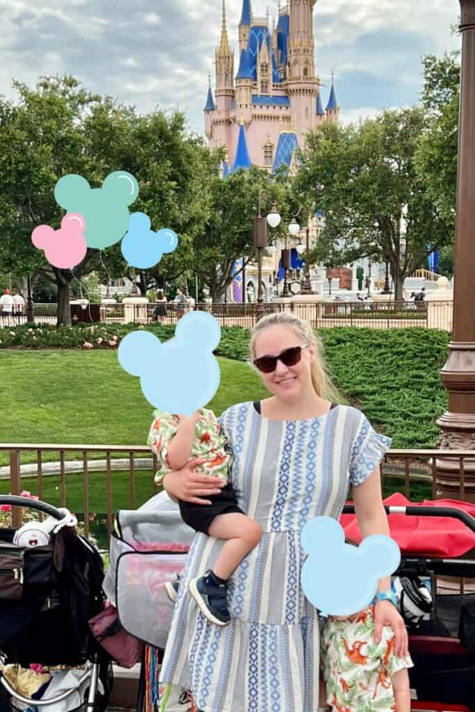 Woman in blue dress standing in front of Cinderella's castle on a Disney vacation