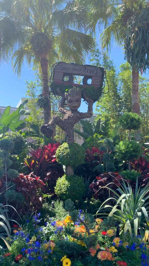 Groot topiary holding a mixed tape over his head